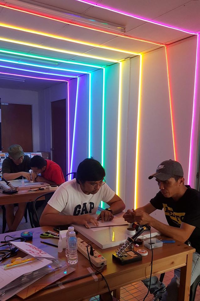 People collaborating on a neon sign project at a Kento workshop